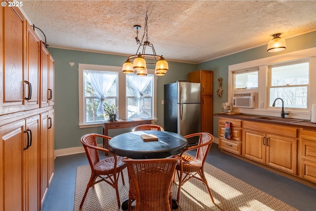 dining space featuring a chandelier, ornamental molding, a textured ceiling, and baseboards