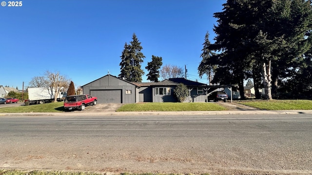 single story home with a carport, a garage, and a front yard