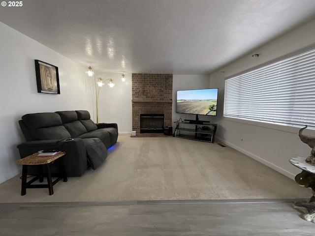 living area featuring a brick fireplace, baseboards, and a textured ceiling