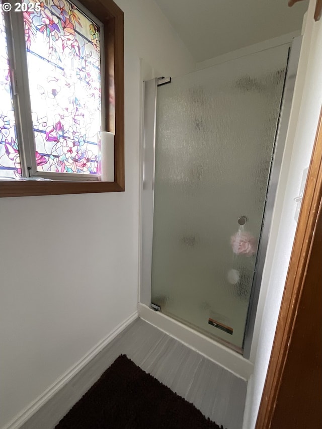 full bathroom featuring a shower stall and baseboards