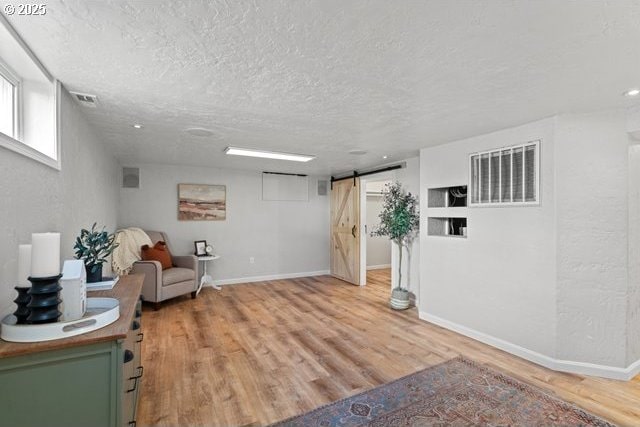 561 E Ridgeway Ave, Hermiston, OR 97838 - living area with a barn door, a textured ceiling, and light wood finished floors