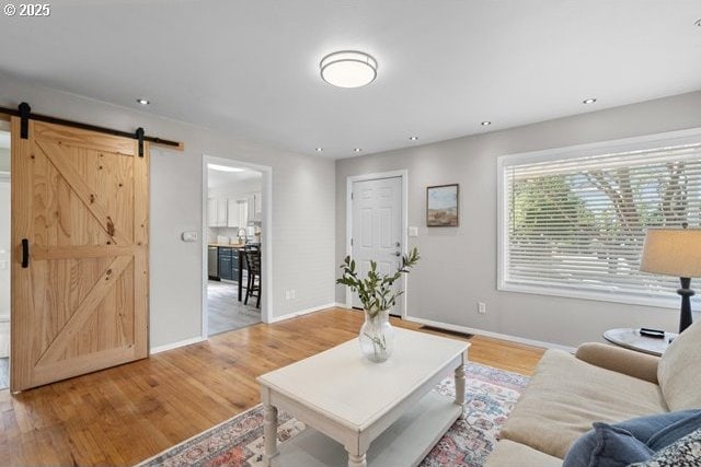 561 E Ridgeway Ave, Hermiston, OR 97838 - living room featuring a barn door, light wood-style flooring, and recessed lighting