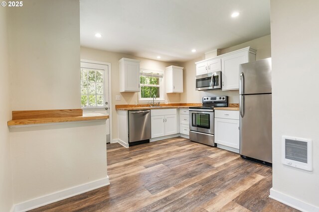 20220 E Peter Pl Unit 3, Sandy, OR 97055 - kitchen featuring stainless steel appliances, heating unit, baseboards, white cabinets, and recessed lighting