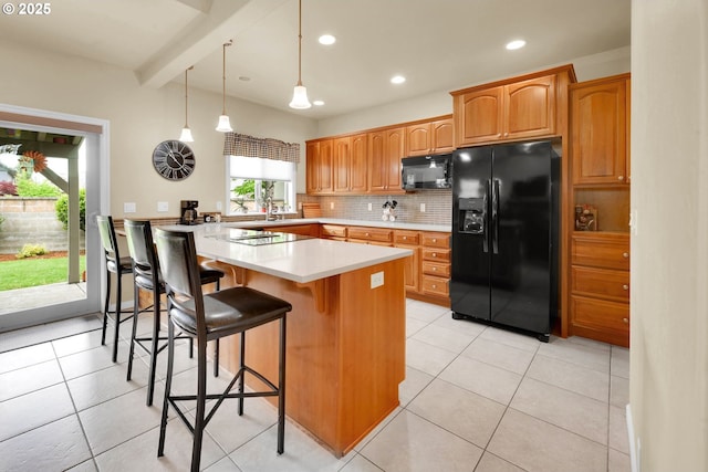kitchen featuring black appliances, backsplash, a breakfast bar, a peninsula, and light countertops
