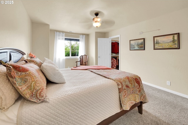 bedroom featuring carpet flooring, baseboards, a walk in closet, and ceiling fan