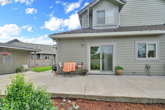 rear view of house with a patio area and fence