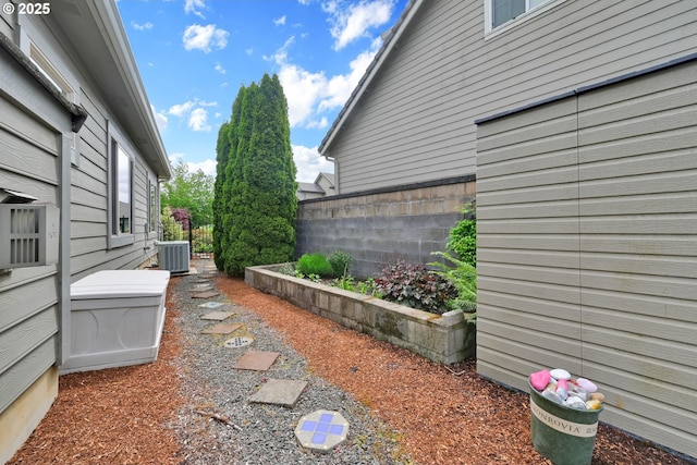 view of yard featuring central AC unit and fence