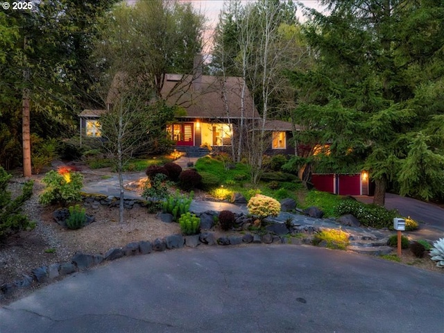 view of yard featuring a garage and aphalt driveway