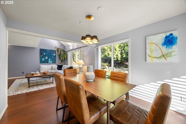 dining room with dark wood-type flooring, baseboards, a chandelier, and vaulted ceiling