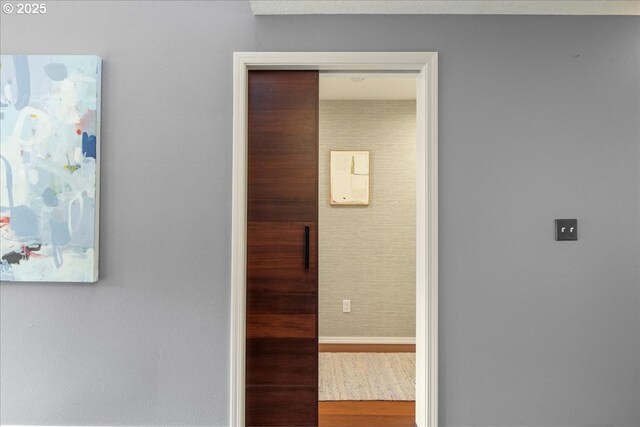 hall with baseboards and wood finished floors