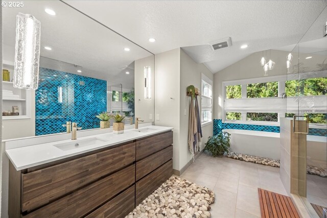 bathroom featuring a sink, visible vents, a freestanding bath, and double vanity