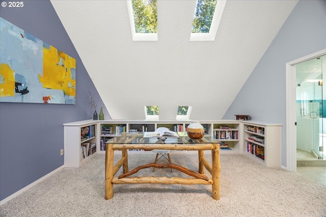 office featuring vaulted ceiling with skylight, baseboards, and carpet flooring