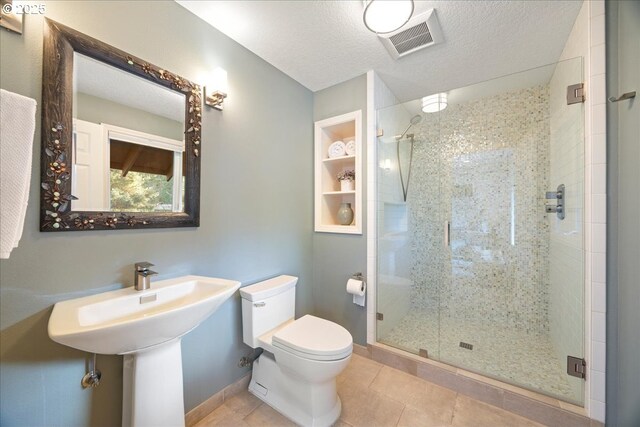 full bath with a stall shower, tile patterned flooring, a textured ceiling, toilet, and visible vents