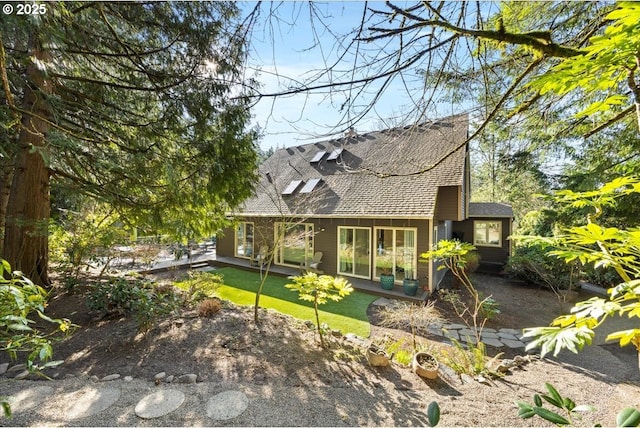 back of property featuring roof with shingles