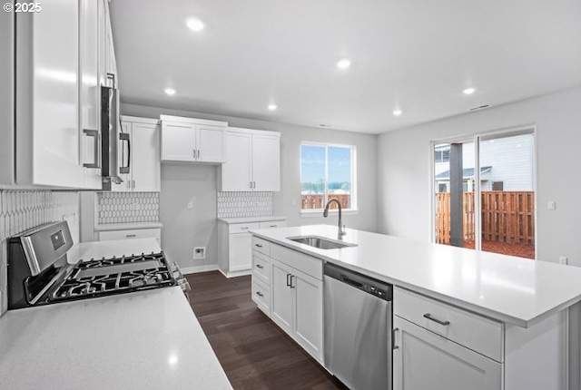 18950 SW Eureka Ln, Beaverton, OR 97007 - kitchen with appliances with stainless steel finishes, dark wood finished floors, white cabinets, light countertops, and recessed lighting