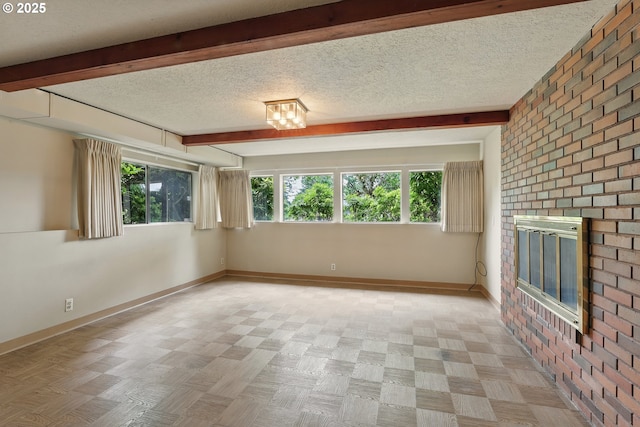 845 NW Day Dr, Gresham, OR 97030 - spare room with beam ceiling, healthy amount of natural light, baseboards, a fireplace, and a textured ceiling
