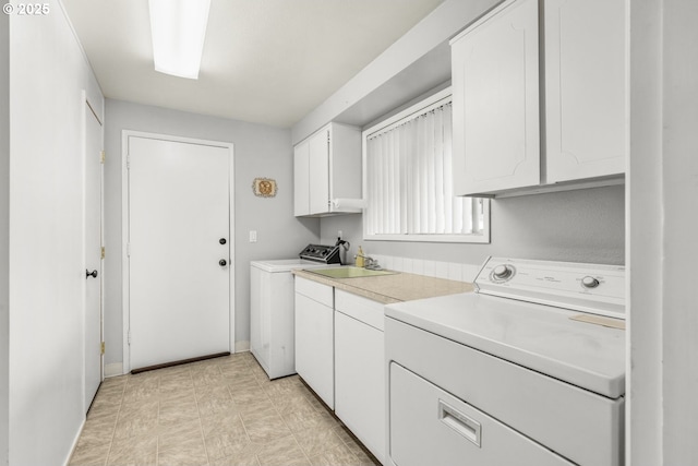 laundry area featuring cabinet space, washer and clothes dryer, and baseboards