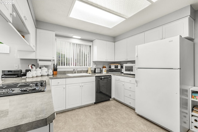 kitchen with black appliances, a sink, white cabinets, and light floors