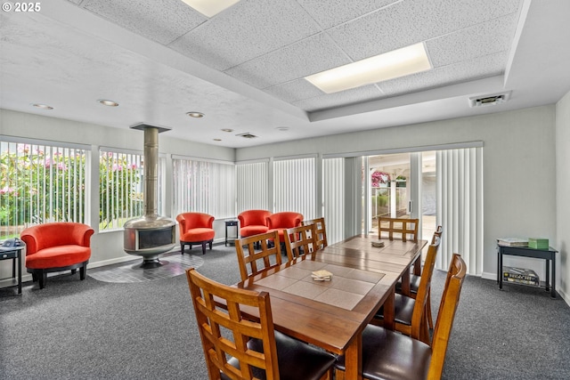 650 Harlow Rd Unit 233, Springfield, OR 97477 - carpeted dining room with baseboards, a wood stove, a tray ceiling, and visible vents