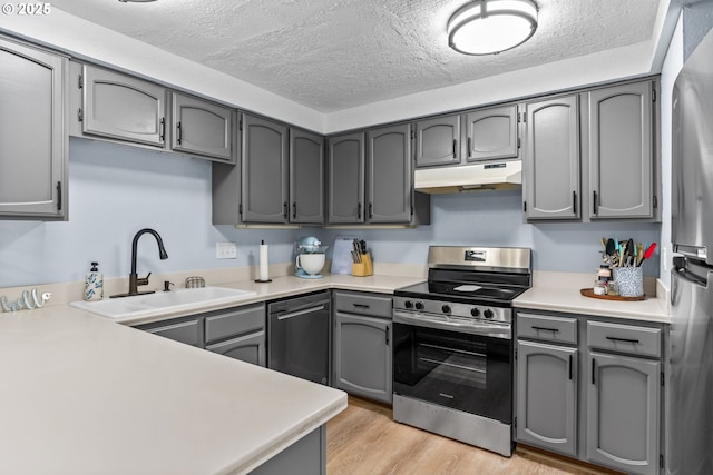 650 Harlow Rd Unit 233, Springfield, OR 97477 - kitchen featuring gray cabinets, a textured ceiling, a sink, under cabinet range hood, and stainless steel appliances