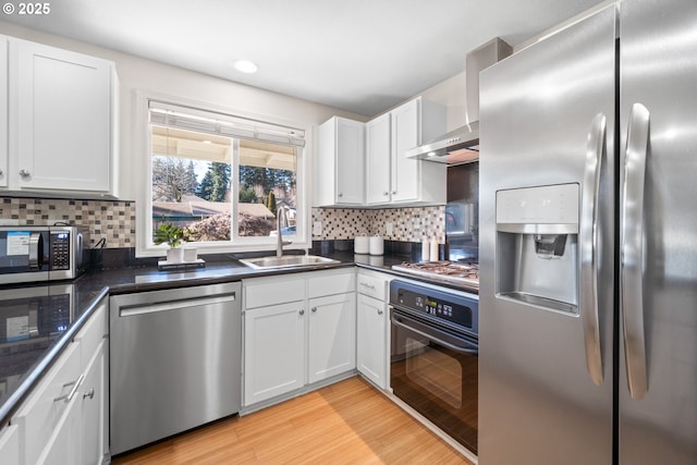 kitchen with white cabinetry, stainless steel appliances, sink, and light hardwood / wood-style flooring