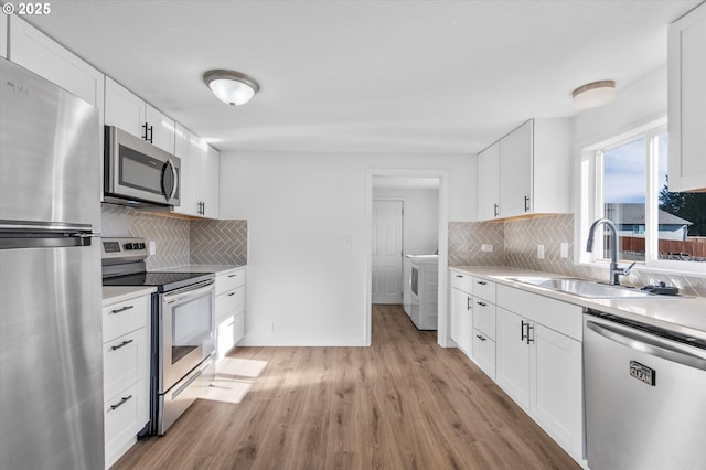 kitchen featuring sink, white cabinetry, light hardwood / wood-style flooring, stainless steel appliances, and decorative backsplash