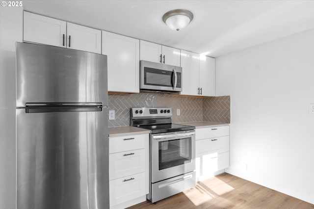 kitchen featuring tasteful backsplash, stainless steel appliances, and white cabinets