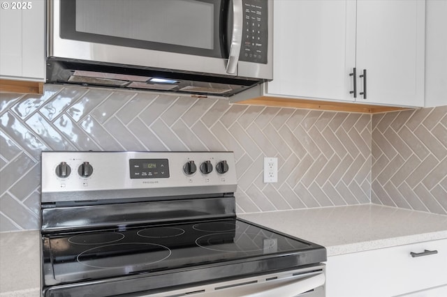 kitchen with white cabinetry, appliances with stainless steel finishes, and decorative backsplash