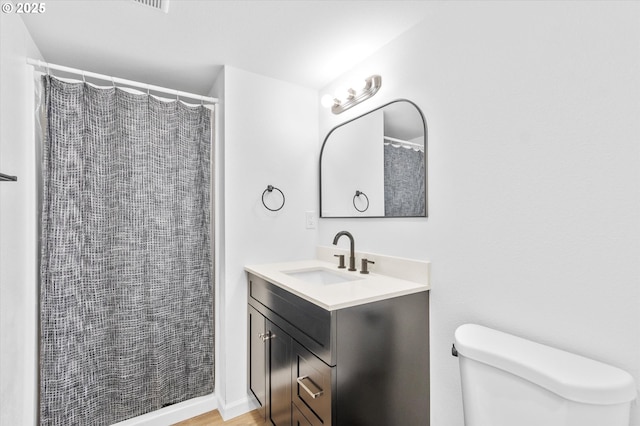 bathroom with vanity, toilet, and curtained shower