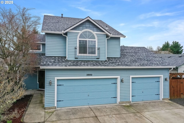 exterior space featuring a garage, fence, driveway, and a shingled roof