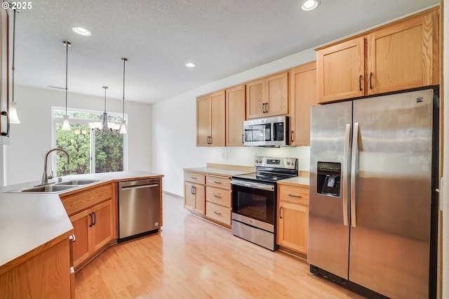 kitchen with light wood-style flooring, recessed lighting, light brown cabinetry, a sink, and appliances with stainless steel finishes