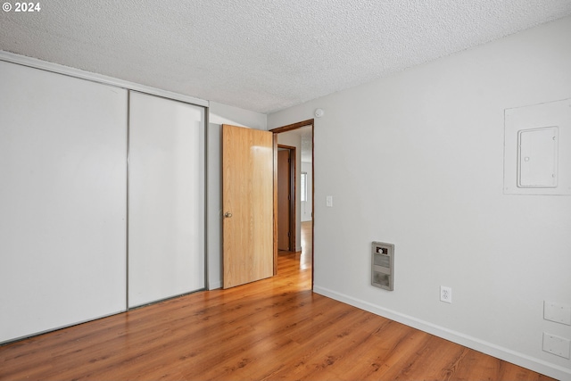 3103/3109 SE 6th Ave, Portland, OR 97202 - unfurnished bedroom with electric panel, a closet, a textured ceiling, and wood finished floors