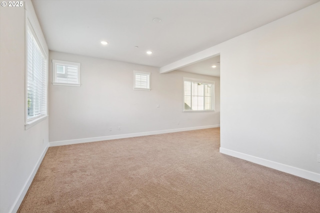 spare room with recessed lighting, baseboards, and light carpet