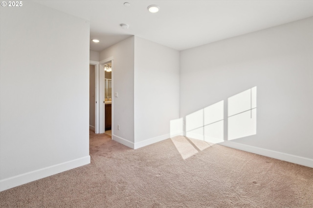 carpeted spare room featuring recessed lighting and baseboards