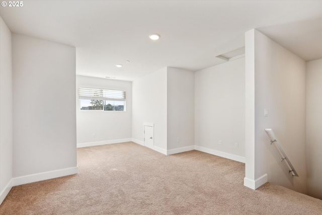 carpeted spare room with recessed lighting, attic access, and baseboards
