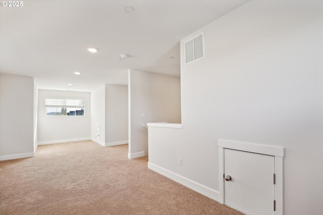 empty room featuring light carpet, visible vents, recessed lighting, and baseboards