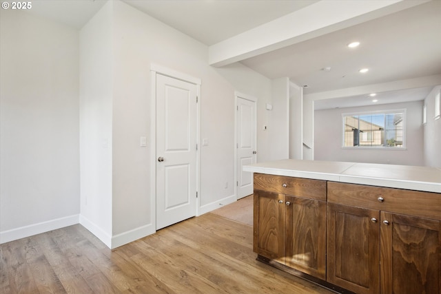 kitchen with light countertops, recessed lighting, light wood-style floors, and baseboards
