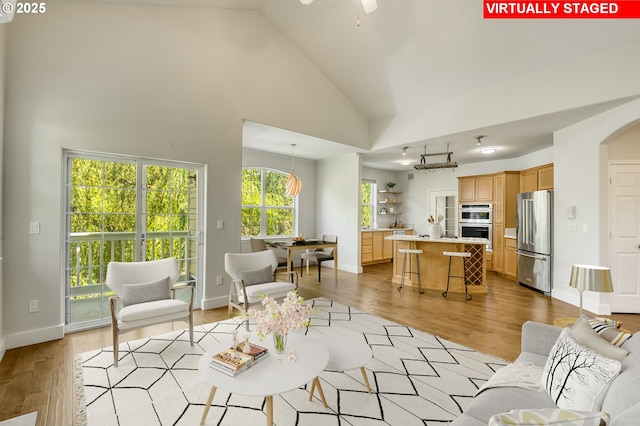 4630 Summerlinn Way W, Linn, OR 97068 - living area featuring light wood-style floors, high vaulted ceiling, a ceiling fan, and arched walkways