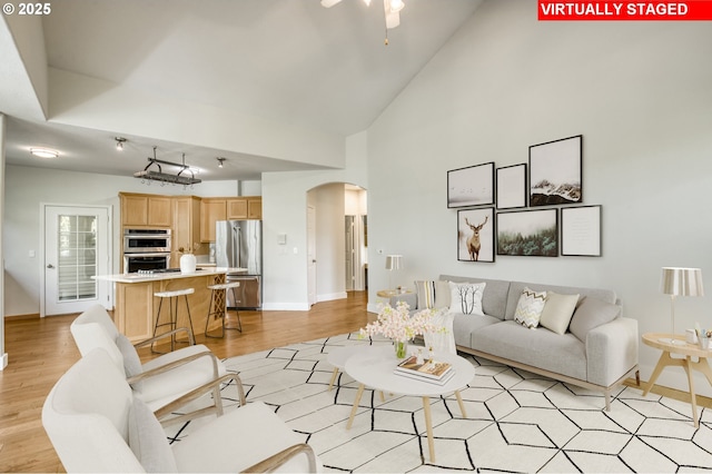4630 Summerlinn Way W, Linn, OR 97068 - living room with arched walkways, high vaulted ceiling, light wood finished floors, and a ceiling fan