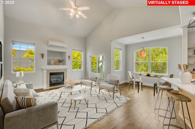 4630 Summerlinn Way W, Linn, OR 97068 - living room featuring high vaulted ceiling, an AC wall unit, wood finished floors, a ceiling fan, and a fireplace with flush hearth