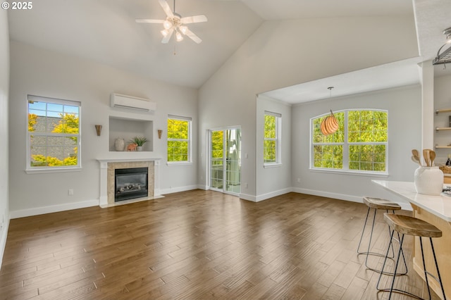 4630 Summerlinn Way W, Linn, OR 97068 - unfurnished living room featuring a wall mounted air conditioner, high vaulted ceiling, ceiling fan, a fireplace with flush hearth, and wood finished floors