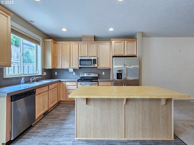 15621 SE Eckert Ln, Damascus, OR 97089 - kitchen featuring appliances with stainless steel finishes, light brown cabinets, decorative backsplash, dark wood-style floors, and a sink