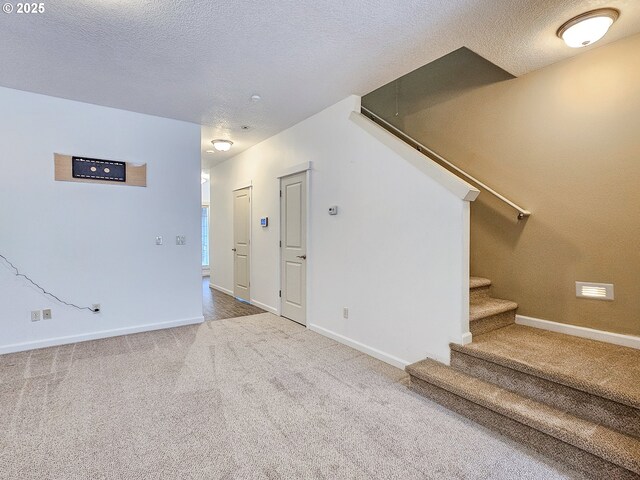 15621 SE Eckert Ln, Damascus, OR 97089 - kitchen with appliances with stainless steel finishes, light carpet, open floor plan, a center island, and a textured ceiling