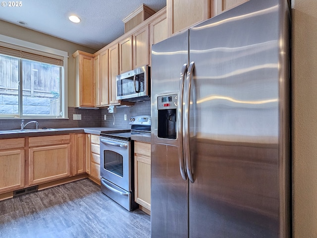 15621 SE Eckert Ln, Damascus, OR 97089 - kitchen with stainless steel appliances, light brown cabinets, wood finished floors, dark countertops, and recessed lighting