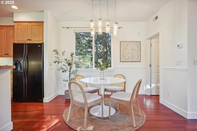 dining room featuring dark wood-type flooring and an inviting chandelier