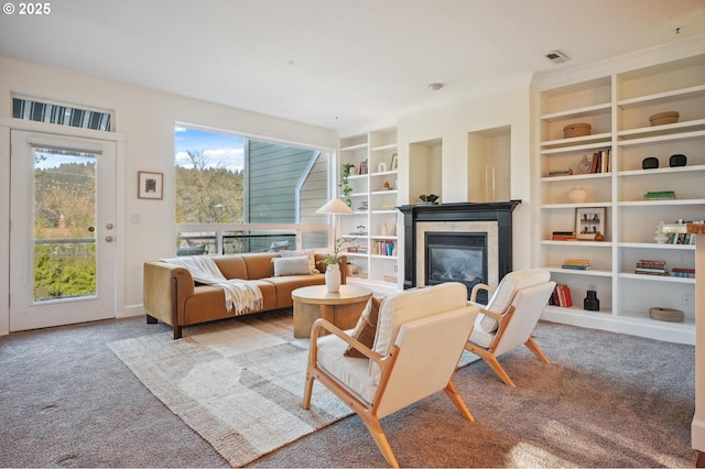 living area featuring built in shelves and light carpet