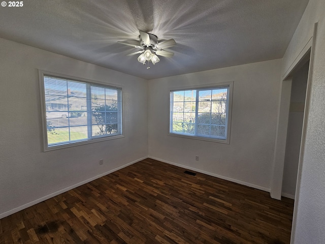 unfurnished bedroom with dark wood-style floors, visible vents, baseboards, and a textured ceiling