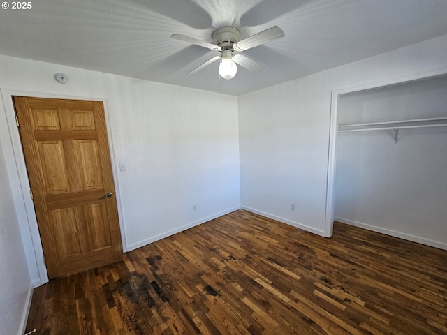 unfurnished bedroom with a ceiling fan, baseboards, dark wood finished floors, and a closet