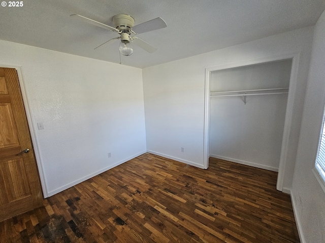 unfurnished bedroom with dark wood-style floors, ceiling fan, a closet, and baseboards