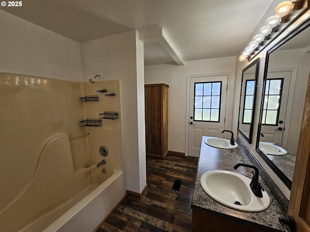 full bath featuring  shower combination, wood finished floors, a sink, and double vanity